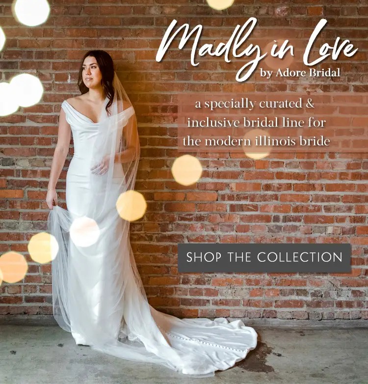 Bride wearing simple gown standing in front of a brick wall